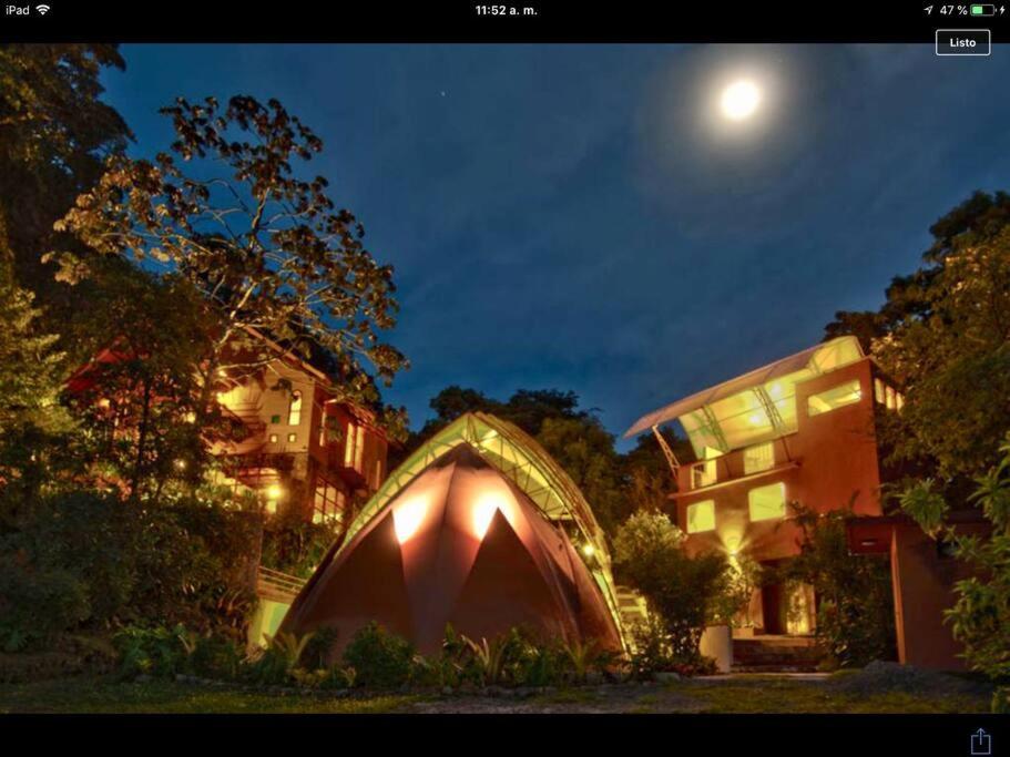una tienda frente a un edificio por la noche en The Cloud Forest Magical Villa, en Monteverde