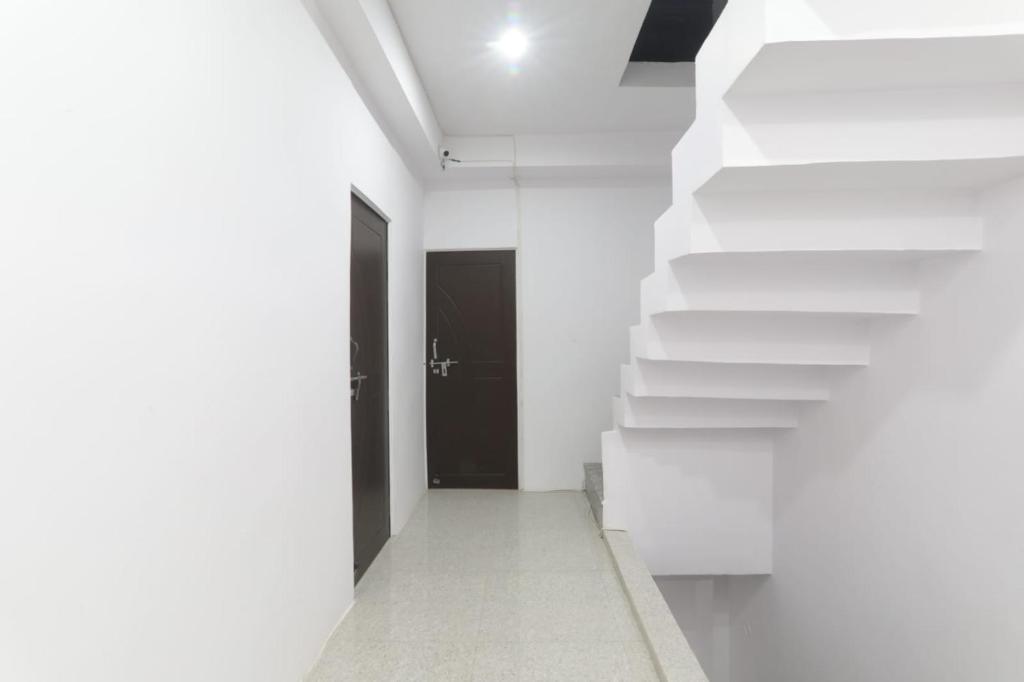 a hallway with white stairs and a black door at KPS inn in Lucknow