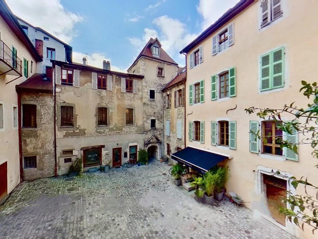 une cour vide dans un vieux bâtiment dans l'établissement Appartement de charme au cœur de la vieille ville, à Annecy