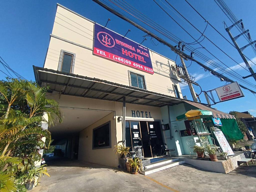 a hotel with a sign on the front of it at Winrisa Place in Nai Yang Beach