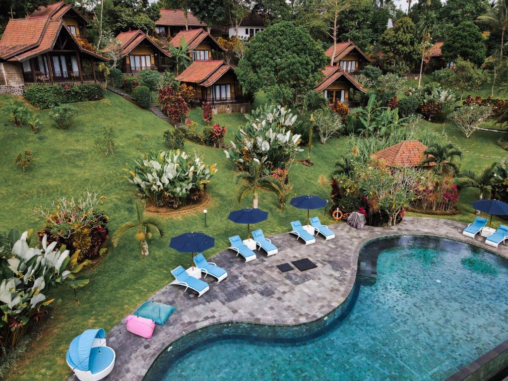 - une vue aérienne sur la piscine du complexe dotée de chaises longues et de parasols dans l'établissement Bali Palms, Tabanan, à Tabanan