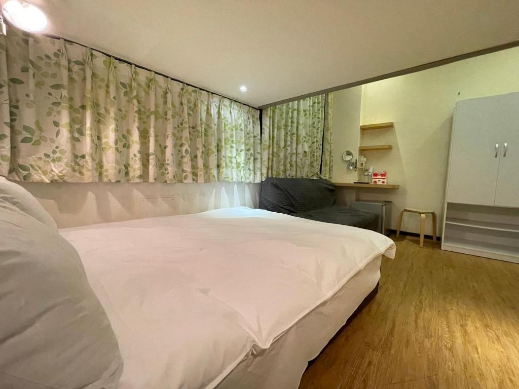 a bedroom with a large white bed and curtains at Dream Travel in Taipei
