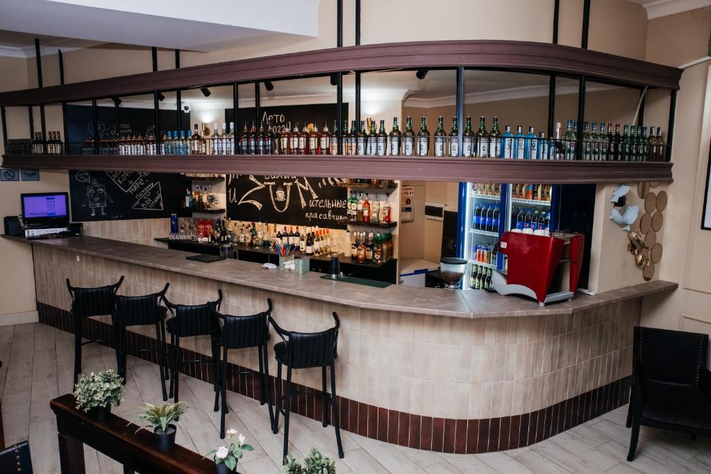 um bar num restaurante com uma fila de bancos em Жемчужина гостиница Балхаш em Balkhash