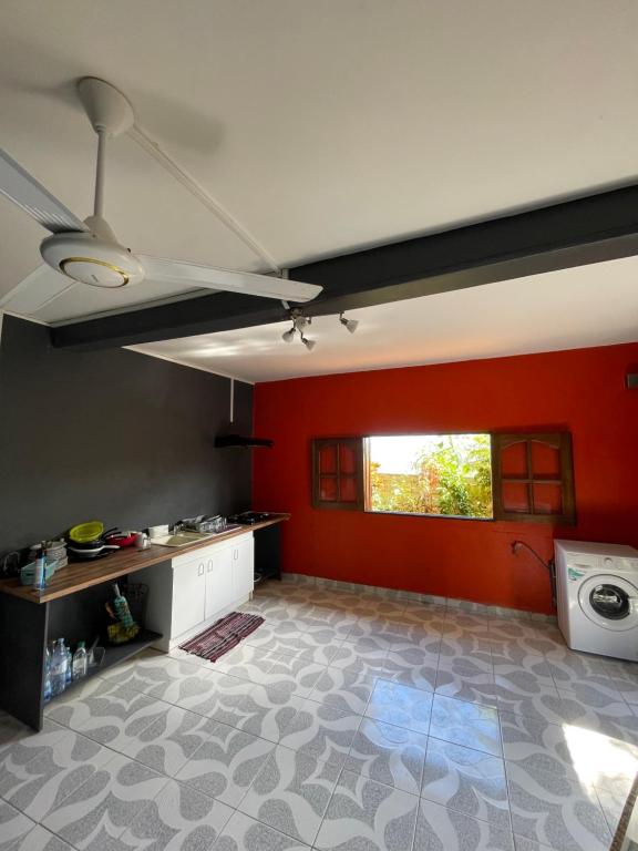 La maison des rives في Sada: مطبخ بجدران حمراء وغسالة ملابس