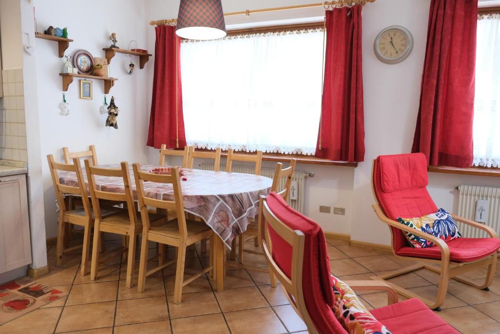 uma sala de jantar com mesa e cadeiras em Al Ruscello em Canazei