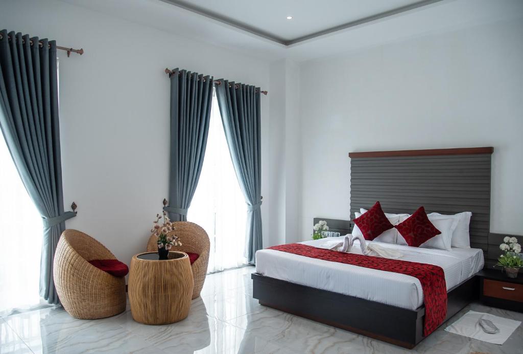 ein Schlafzimmer mit einem großen Bett mit roten Kissen in der Unterkunft The Pharo in Nittambuwa