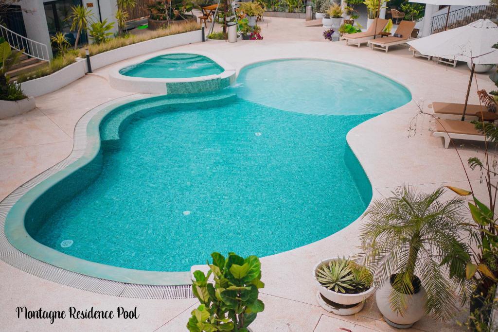 una gran piscina en un patio con plantas en Montagne Regency en Kampot