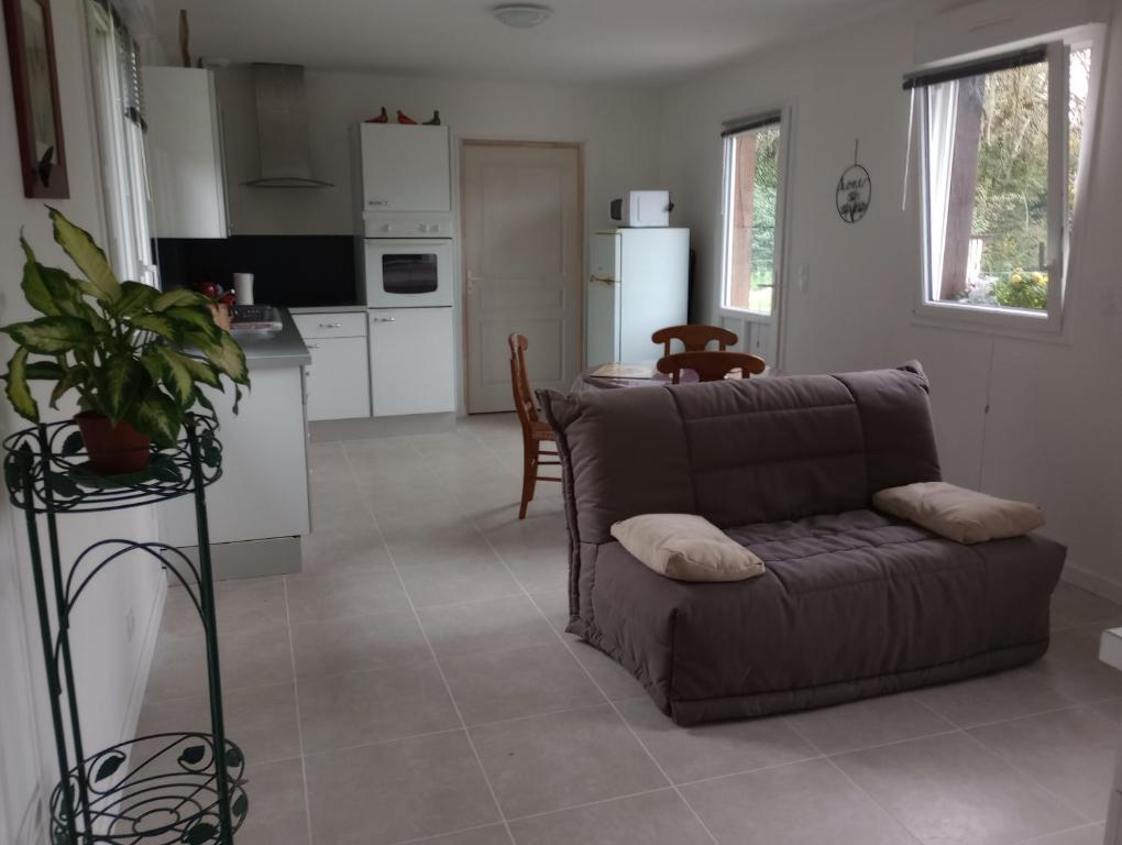 a living room with a couch and a kitchen at La Cour Angot in Cormeilles