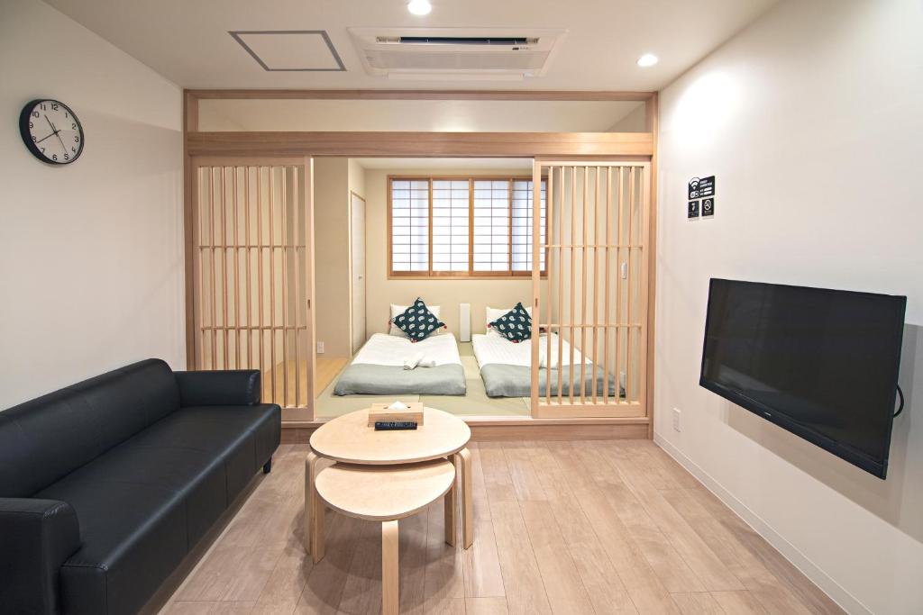 een woonkamer met een bank en een tafel bij 拾野の家 202和室 in Osaka