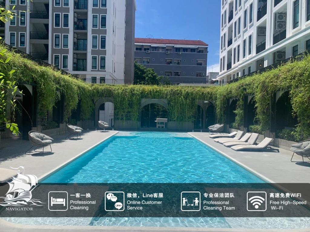 a swimming pool with chairs and ivy on a building at Aspire Ratchada精品公寓 in Bangkok