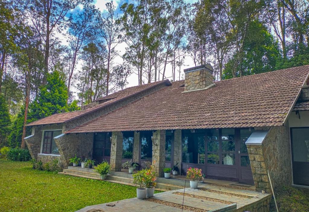 a stone house with a shingled roof at Avadale Munnar (Stag Groups Not Allowed) in Chinnakanal