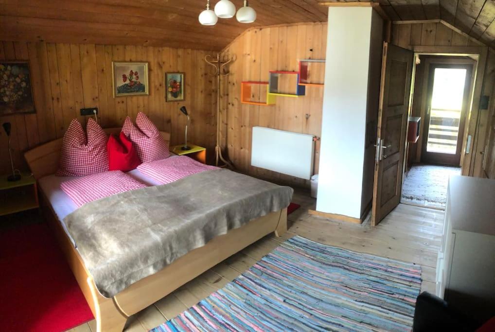 1 dormitorio con cama con almohadas rosas y alfombra en Villa Alberto - gemütliches Häuschen, en Ötztal-Bahnhof