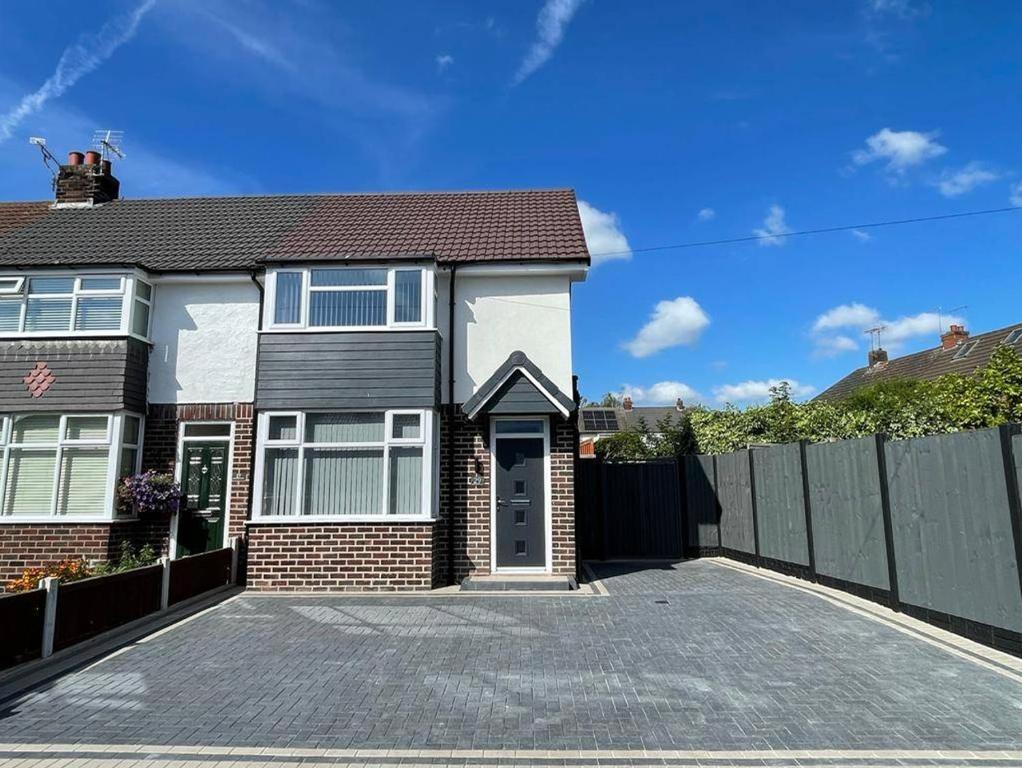 een stenen huis met een hek en een oprit bij Gable House in Crewe