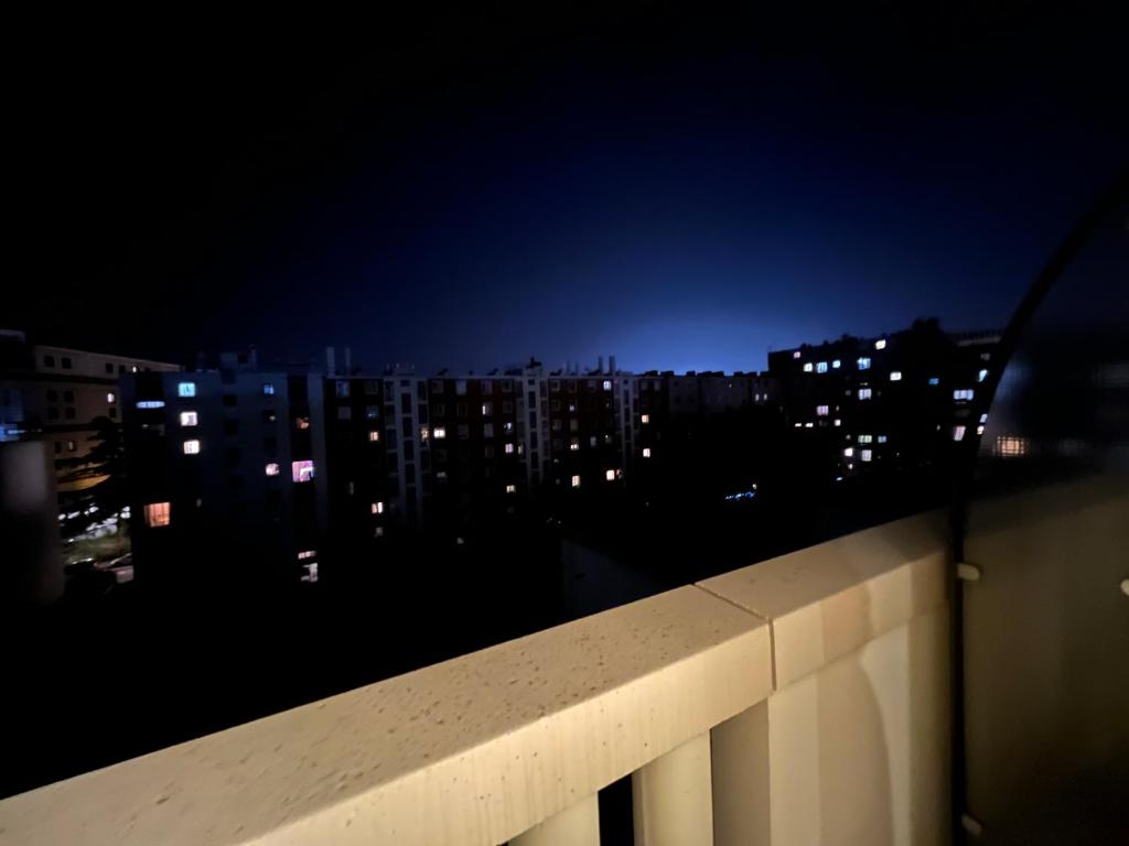 une vue sur les toits d'une ville la nuit dans l'établissement Dream Dwell Paris - Paris Expo Porte Versailles beautiful apartment with balcony, à Issy-les-Moulineaux