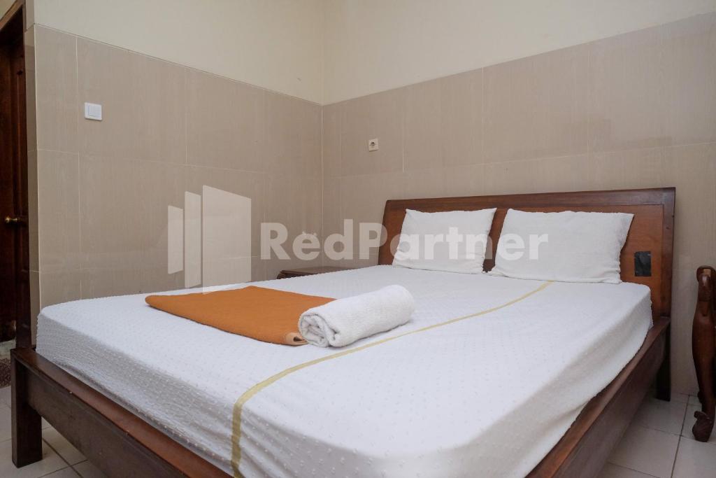 Postel nebo postele na pokoji v ubytování Wisma Garuda Syariah Condoongcatur Mitra RedDoorz