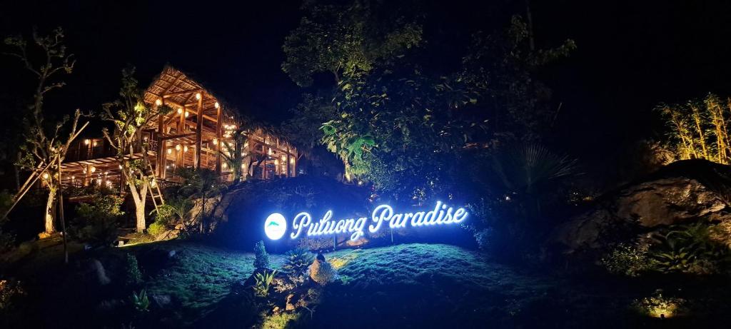 Un panneau qui dit un paradis d'anaheim la nuit dans l'établissement Pu Luong Paradise, à Hương Bá Thước