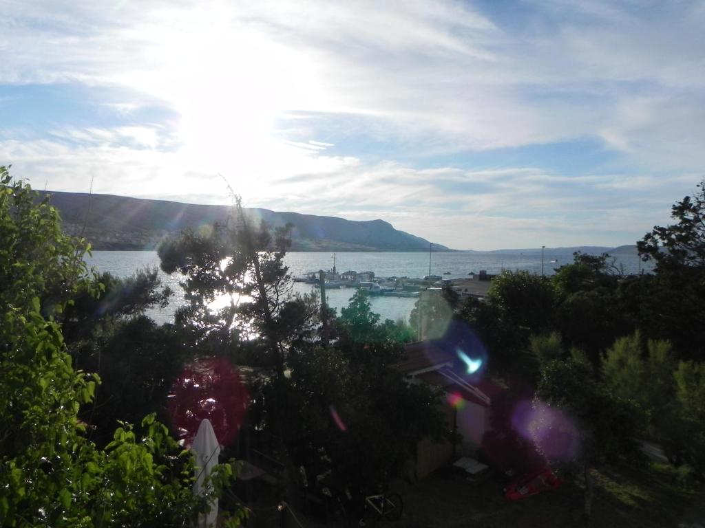 a view of a body of water with the sun shining at Apartments Riva in Pag
