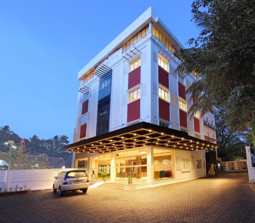 a car parked in a parking lot in front of a building at National Park residency in Ettumānūr