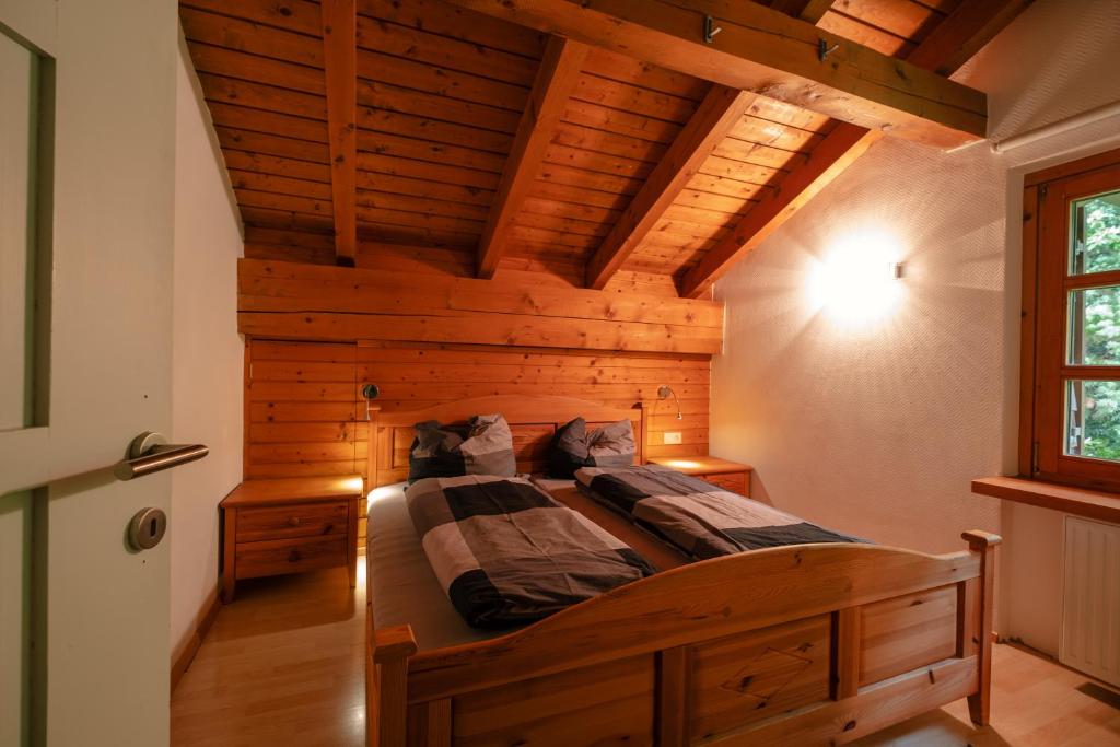 a large bed in a room with a wooden ceiling at Haus Maschol in Wald am Arlberg