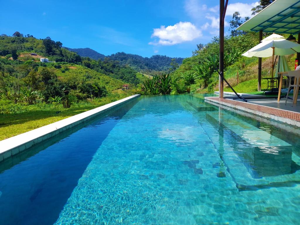 een zwembad in een resort met een berg op de achtergrond bij The Hill in Kampong Sum Sum