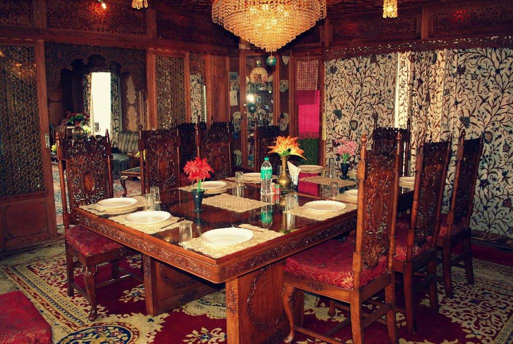 uma sala de jantar com uma grande mesa de madeira e cadeiras em Houseboat em Ameerpet
