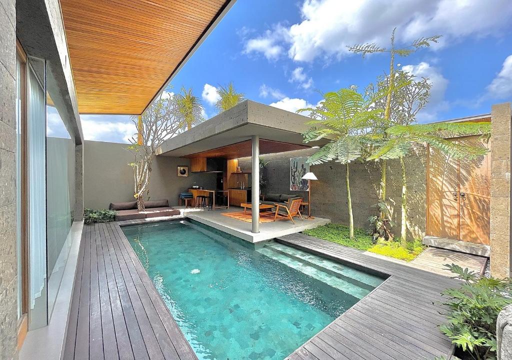 einen Pool im Hinterhof eines Hauses in der Unterkunft Domisili Villas Canggu Bali by Fays Hospitality in Canggu