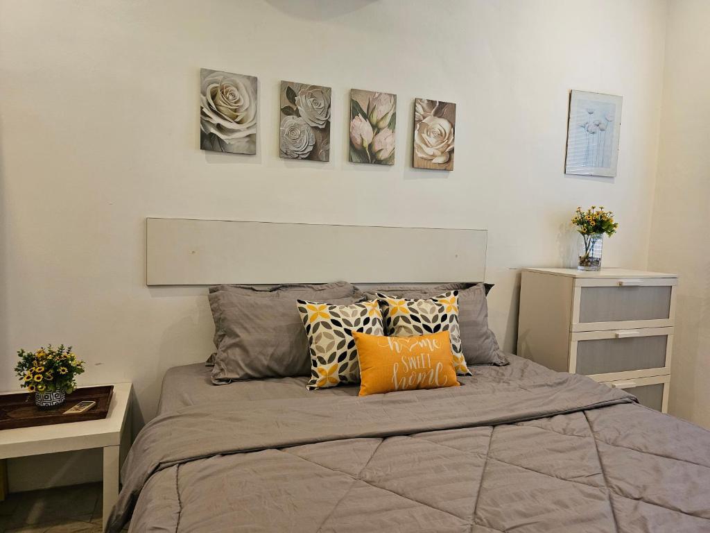 a bedroom with a bed with four paintings on the wall at Soul Casa Homestay in Kuala Lumpur