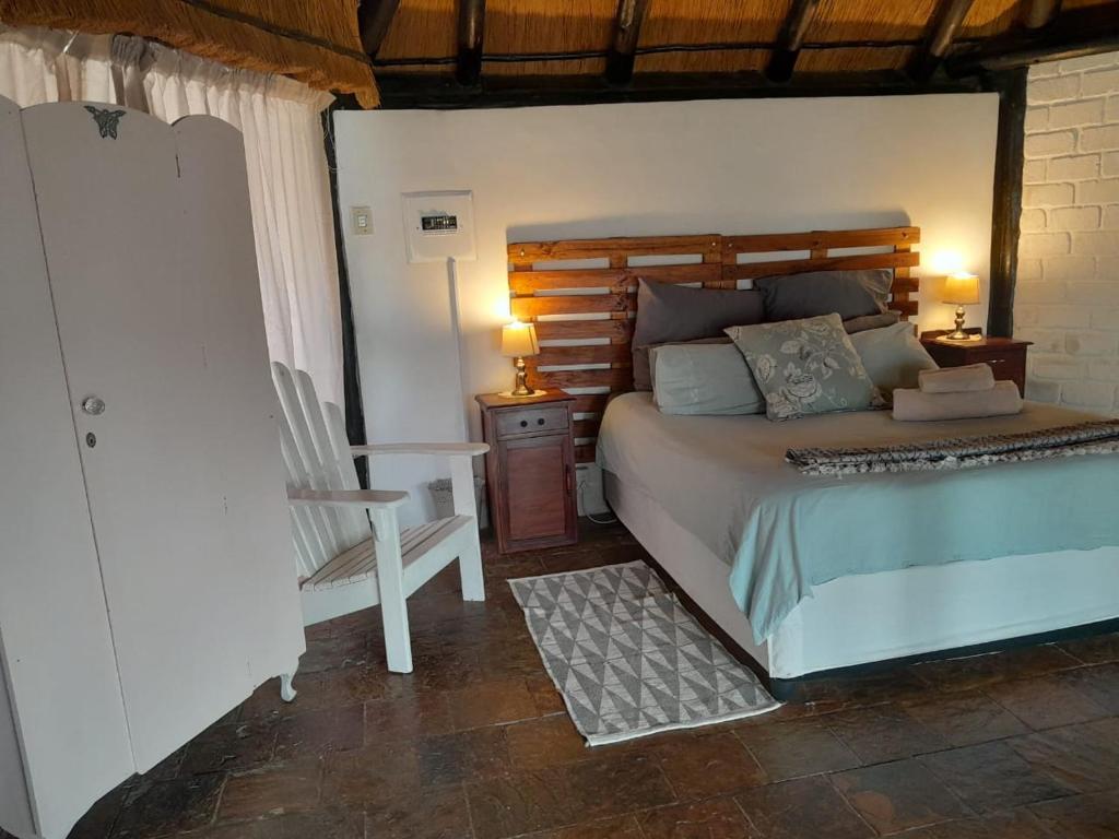 a bedroom with a bed and a chair and a table at The Lapa Apartment in Gobabis