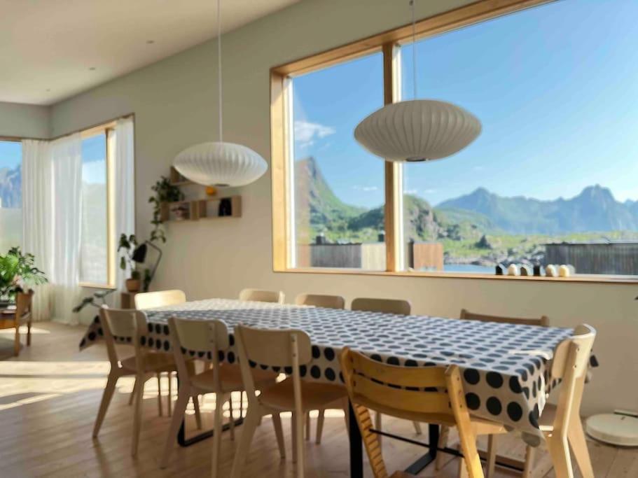 a dining room with a table and chairs and a large window at House in Lofoten, beautiful view/ Hus i Lofoten in Kabelvåg