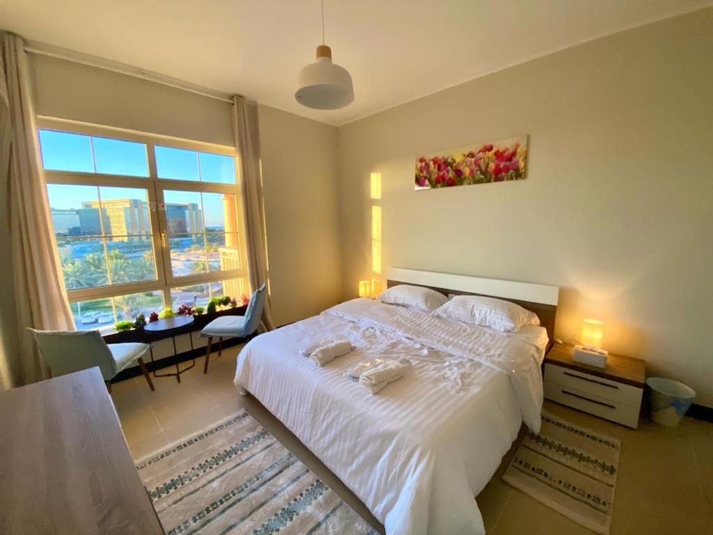 Schlafzimmer mit einem Bett, einem Tisch und einem Fenster in der Unterkunft Marina Deluxe 2, family only in King Abdullah Economic City