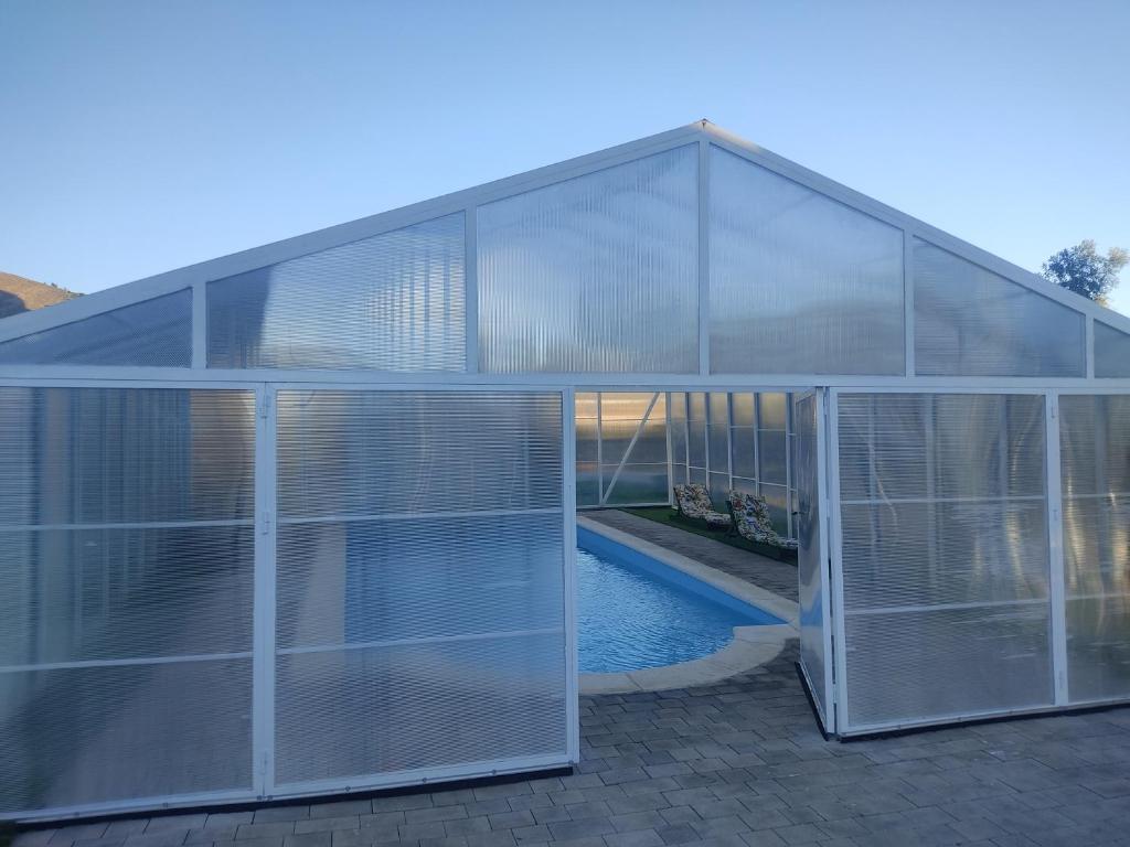 uma casa de vidro com piscina em Hotel Rural Familiar Almirez-Alpujarra em Laujar de Andarax