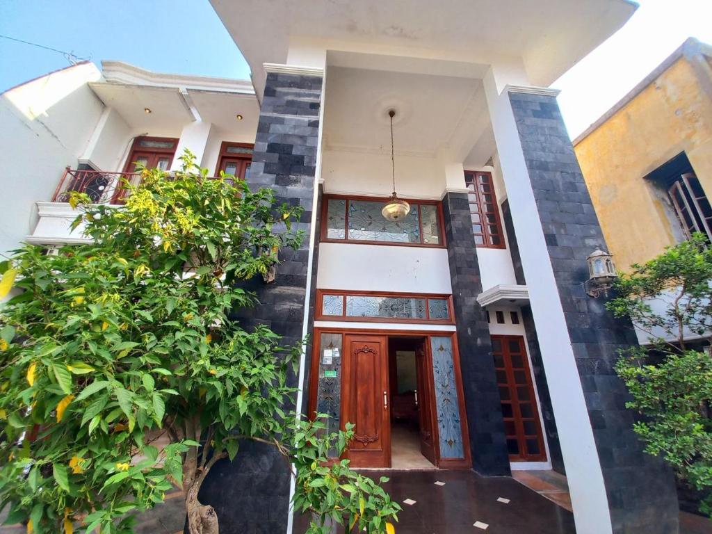 a facade of a house with a red door at Homestay Jogja Samirono Dekat UNY by Simply Homy in Yogyakarta