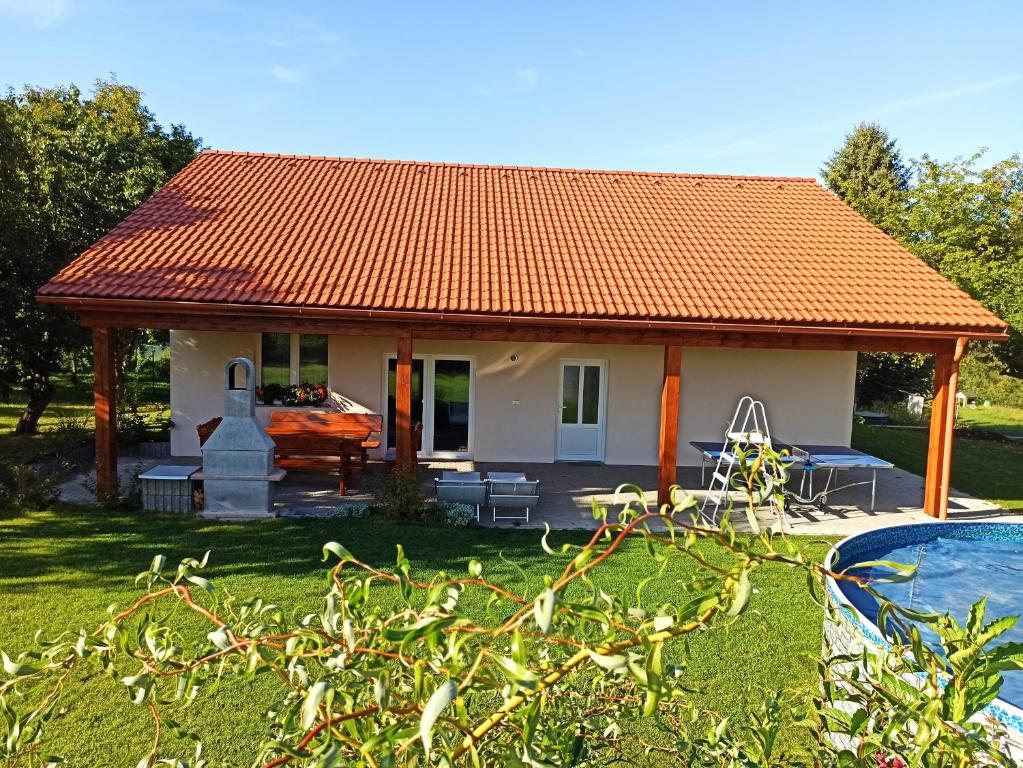 une petite maison avec un toit orange à côté d'une piscine dans l'établissement Prázdninový dům Adrelot 33, 