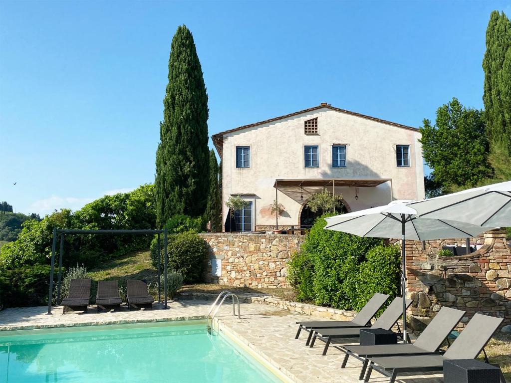 a house with a pool and chairs and an umbrella at Villa Tre Colli - In The Heart Of Tuscany in Certaldo