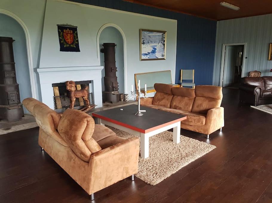 a living room with two couches and a coffee table at Løkhaugen - Historisk landsted in Slettvik