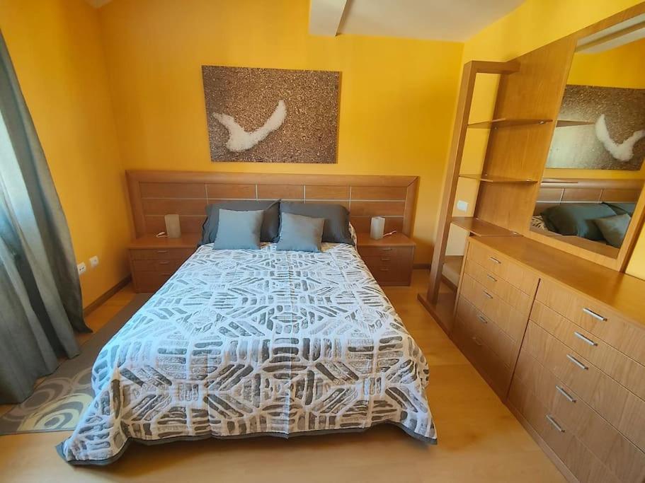una camera con un letto e una parete gialla di Ático Duplex CALLE MAYOR a El Burgo de Osma