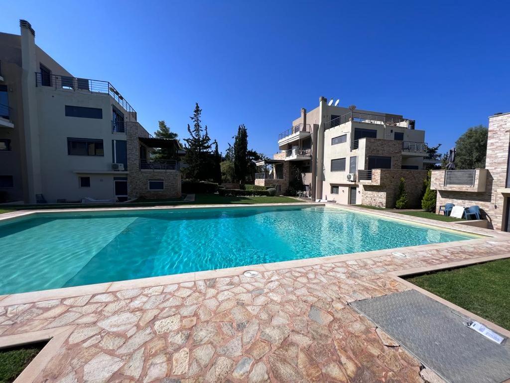 una gran piscina frente a un edificio en Pool apartment 5 minutes walk from beach, en Porto Rafti