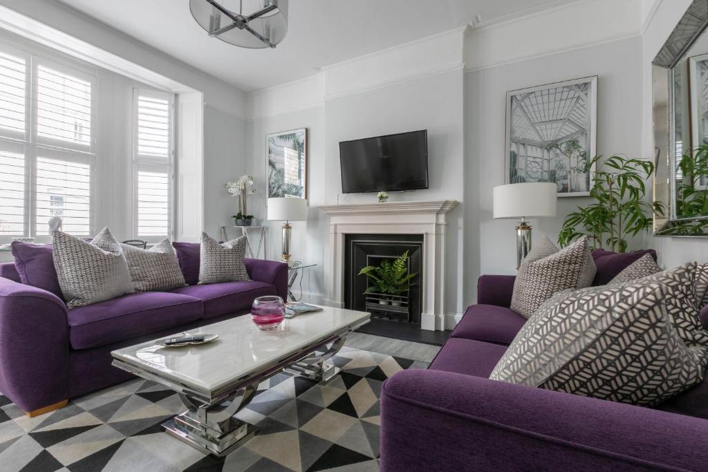 sala de estar con muebles de color púrpura y chimenea en Luxury 1BR Broadstairs: 2 mins walk to the beach en Kent