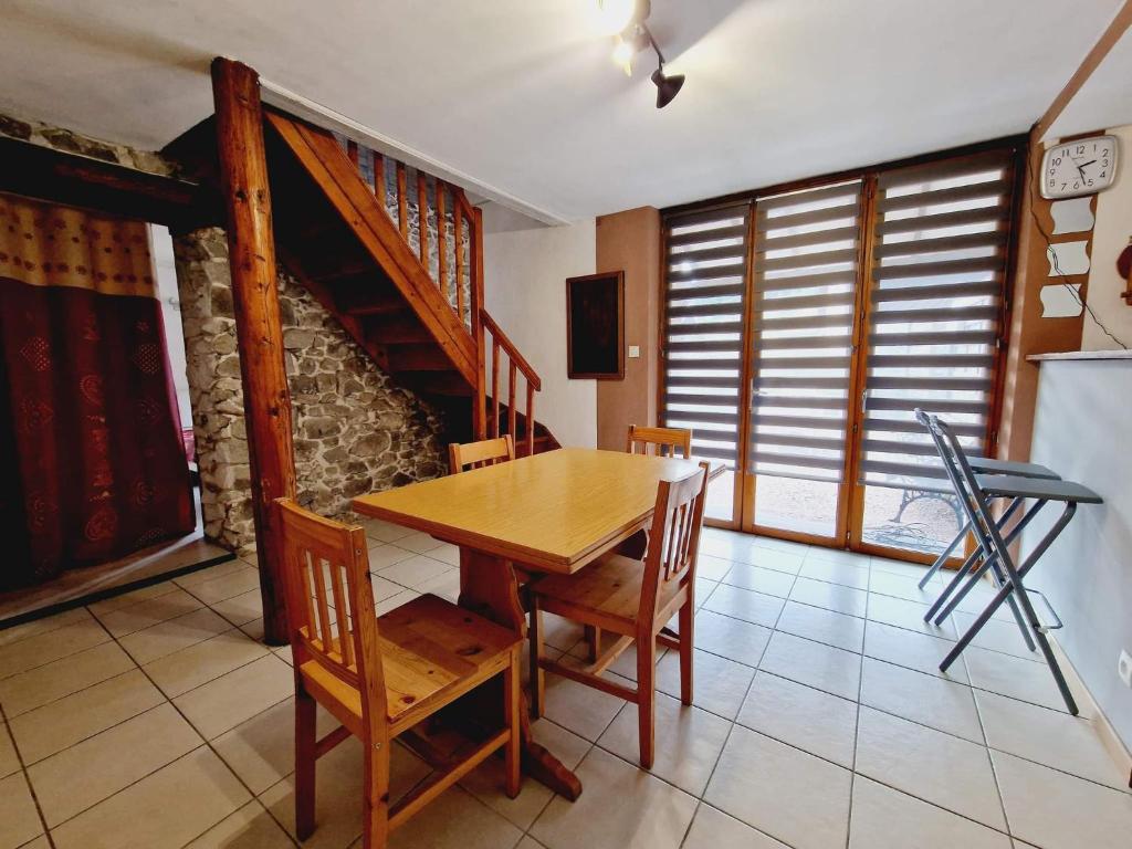 a dining room with a wooden table and chairs at Le Petit Veternat in Ventron