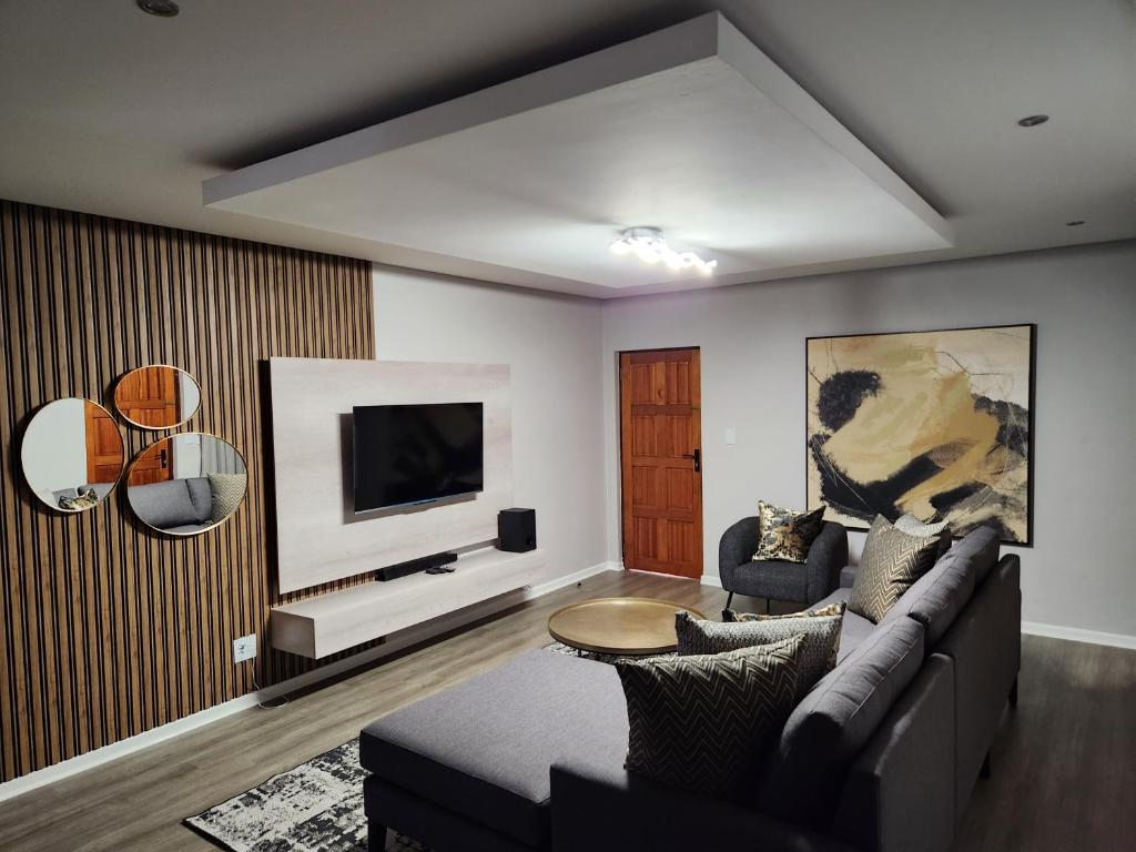 uma sala de estar com um sofá e uma televisão em Villa Casa Lifestyle em Nelspruit