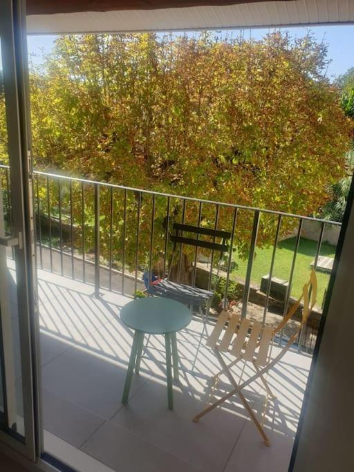 a balcony with a table and a chair on a porch at spacieux T2 confortable in Saint-Vallier