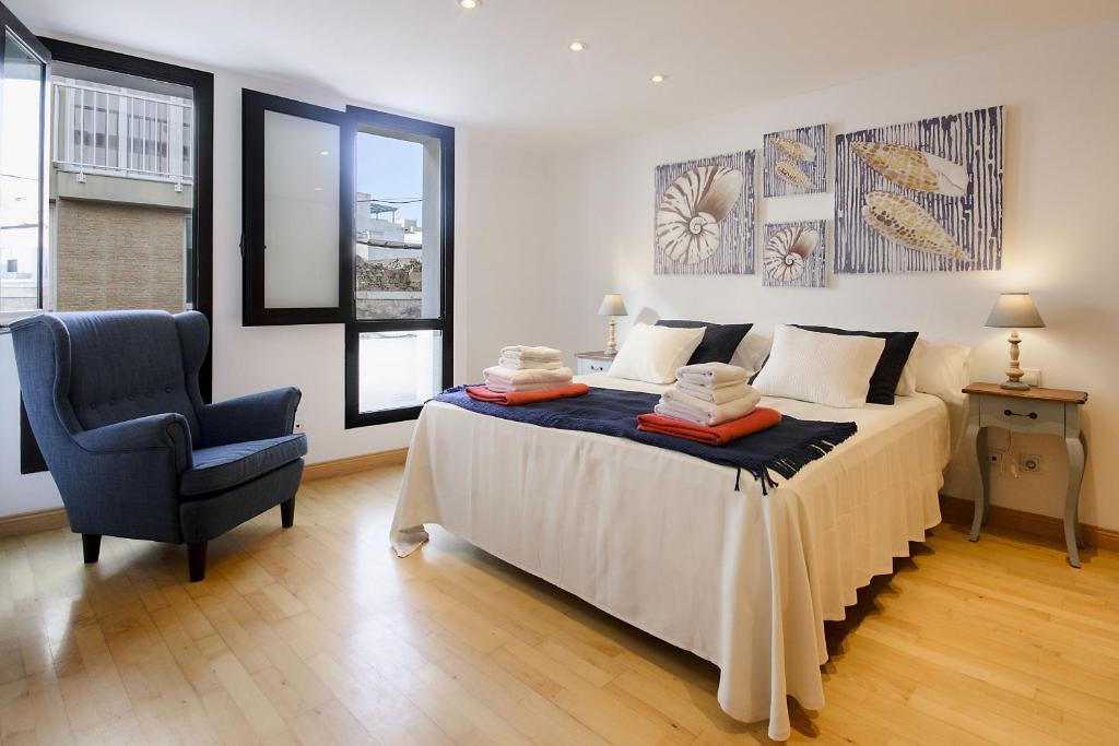 a bedroom with a bed and a blue chair at El Estudio de Lela in Arrecife