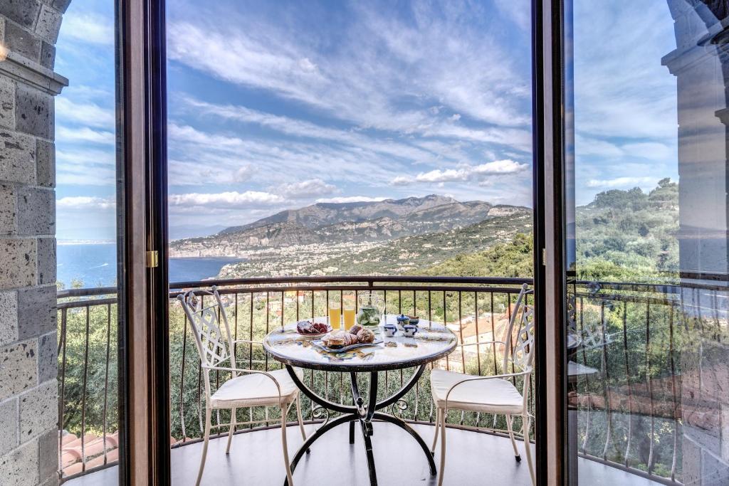 a table on a balcony with a view of the ocean at Villa Caruso with Private Pool in Sorrento