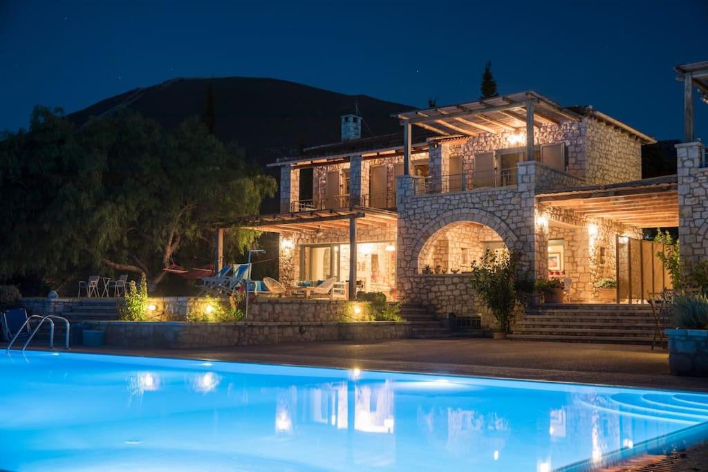 una casa con piscina por la noche en Villa Leon, en Chalkida