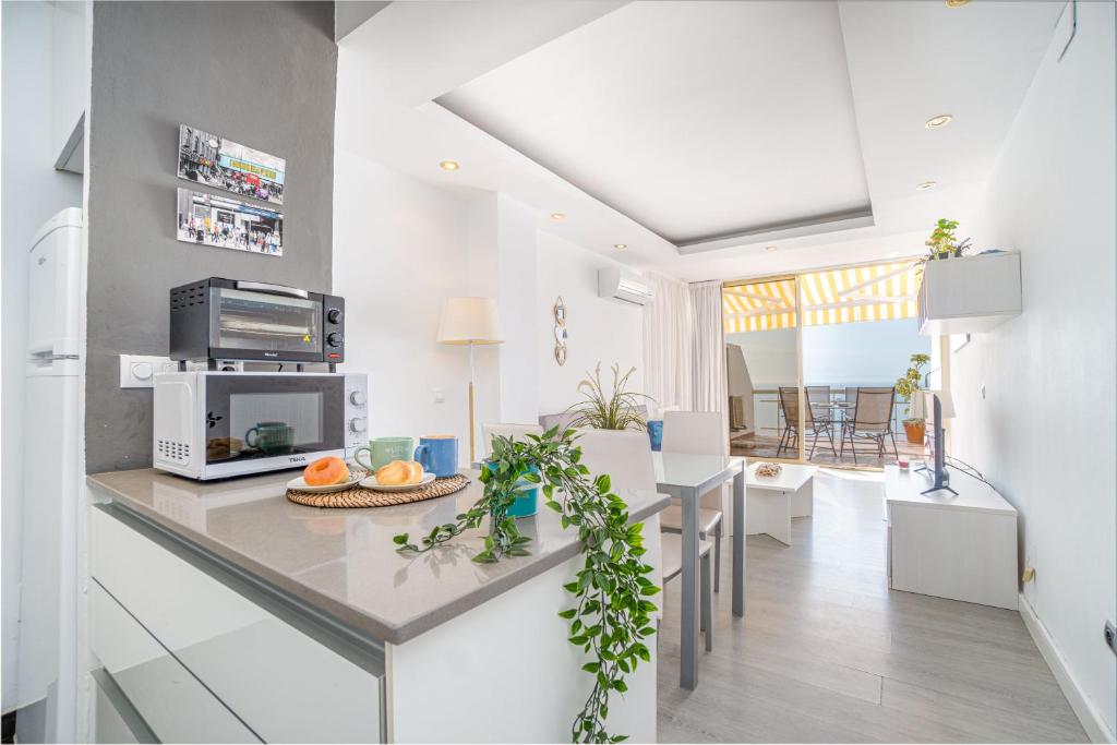 Una cocina y una sala con una mesa y un comedor. en Apartment Meda Chica, en Roses