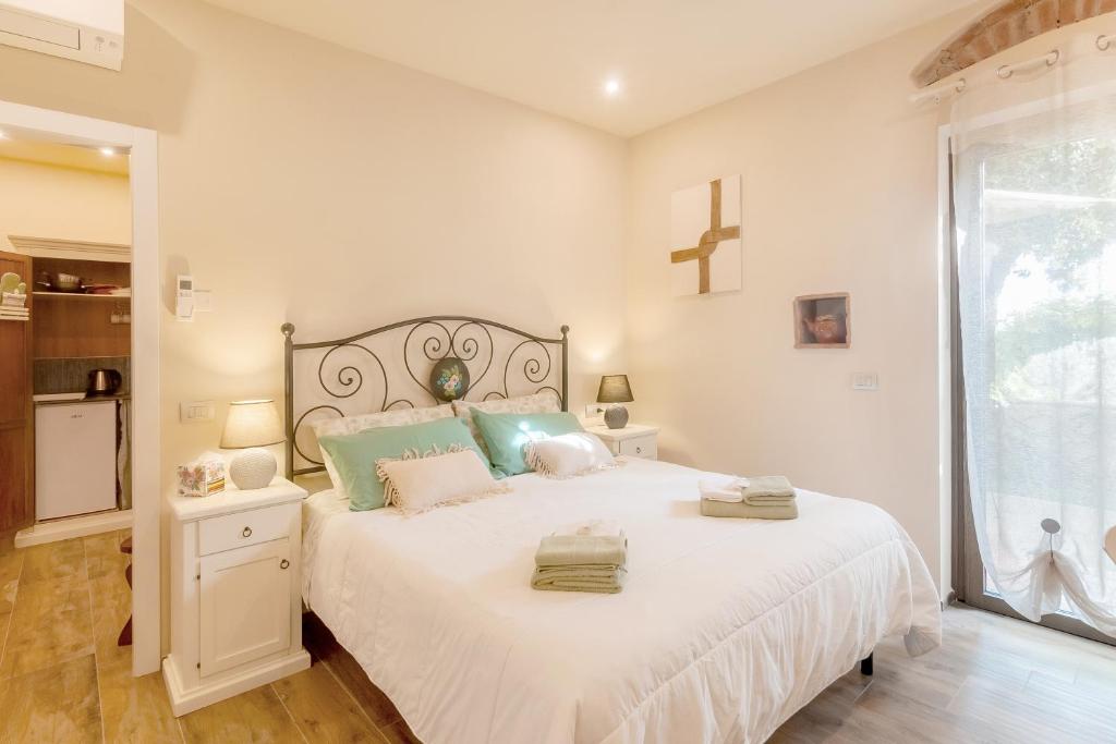 ein Schlafzimmer mit einem großen Bett mit einem Kreuz an der Wand in der Unterkunft Il Piccolo Borgo - con vista in Certaldo