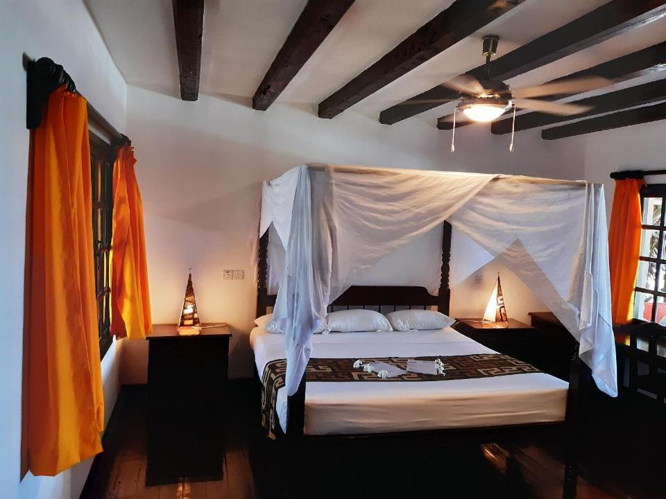 a bedroom with a bed with a mosquito net at Blue Bay Village in Watamu