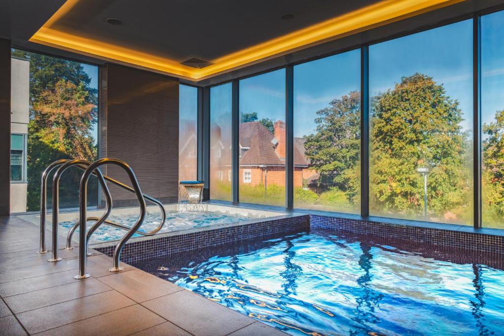 a swimming pool in a house with windows at Harbour Hotel & Spa Guildford in Guildford