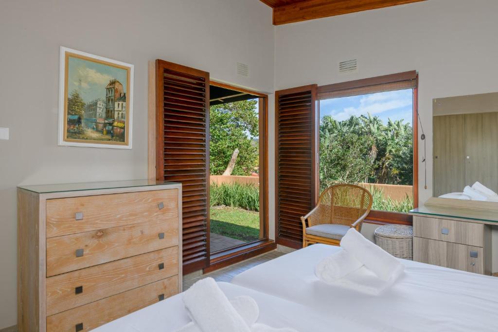 a bedroom with a bed and a large window at San Lameer Villa 3314 - 2 Bedroom Superior - 4 pax - San Lameer Rental Agency in Southbroom
