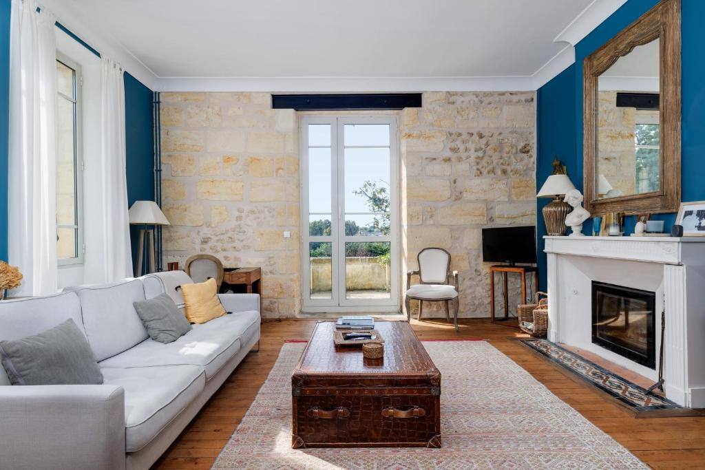 ein Wohnzimmer mit einer weißen Couch und einem Kamin in der Unterkunft La Papautiere in Carignan